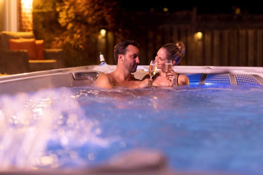 Couple relaxing in romantic Hot Tub with glass of champagne
