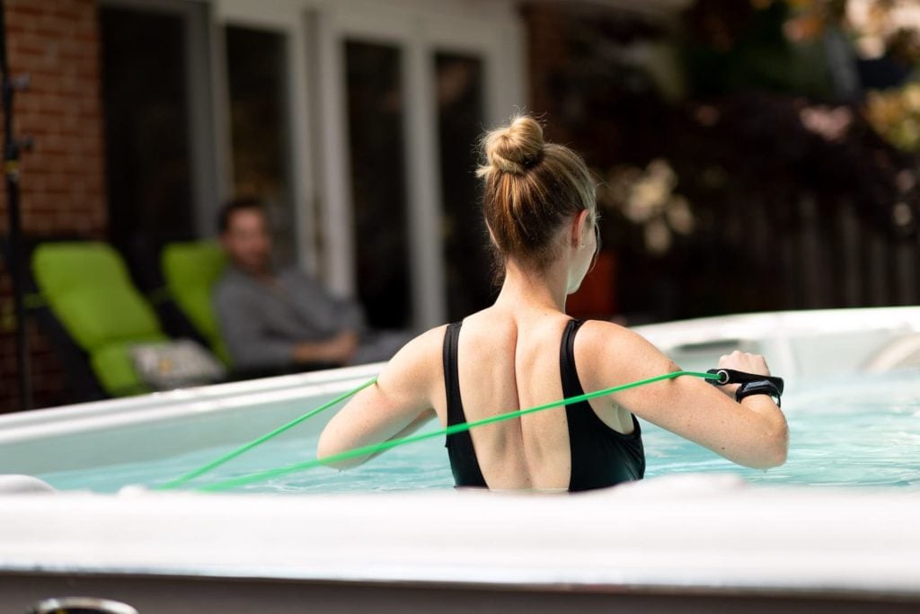 Woman using resistance bands in swim spa